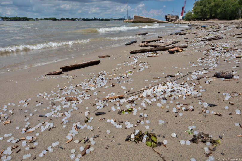 Plastic nurdles scattered on a beach along the Mississippi