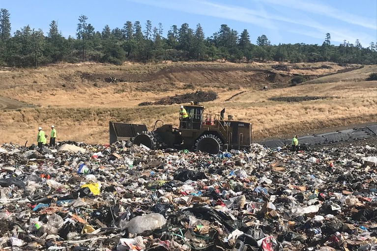 Landfill workers bury all plastic